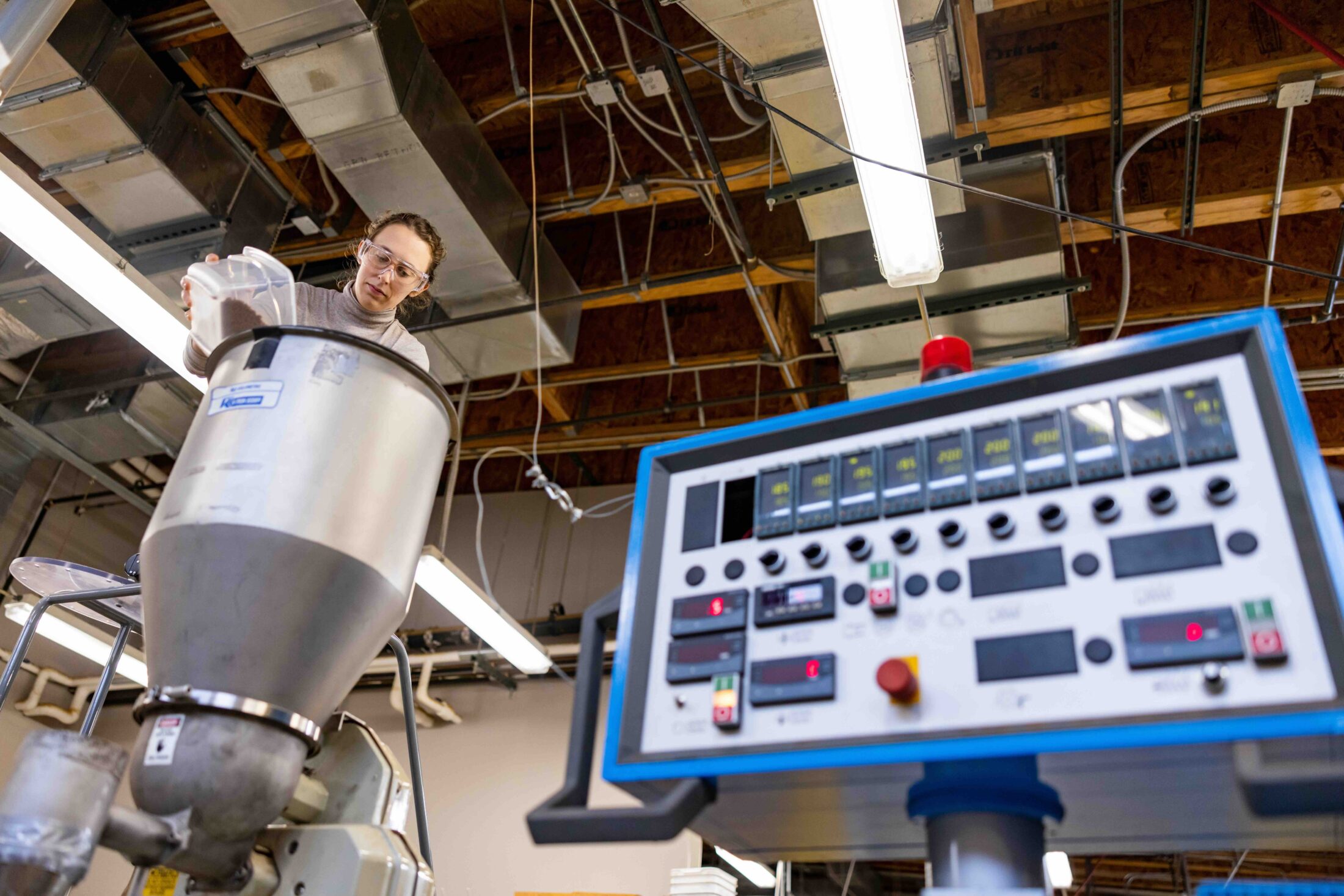 Cecile Grubb, graduate student, feed pellets and natural fibers into an extruder using feed equipment accessed by ladder inside a Center for Renewable Carbon (CRC) lab at the Agriculture campus on December 09, 2022. Photo by Steven Bridges/University of Tennessee.