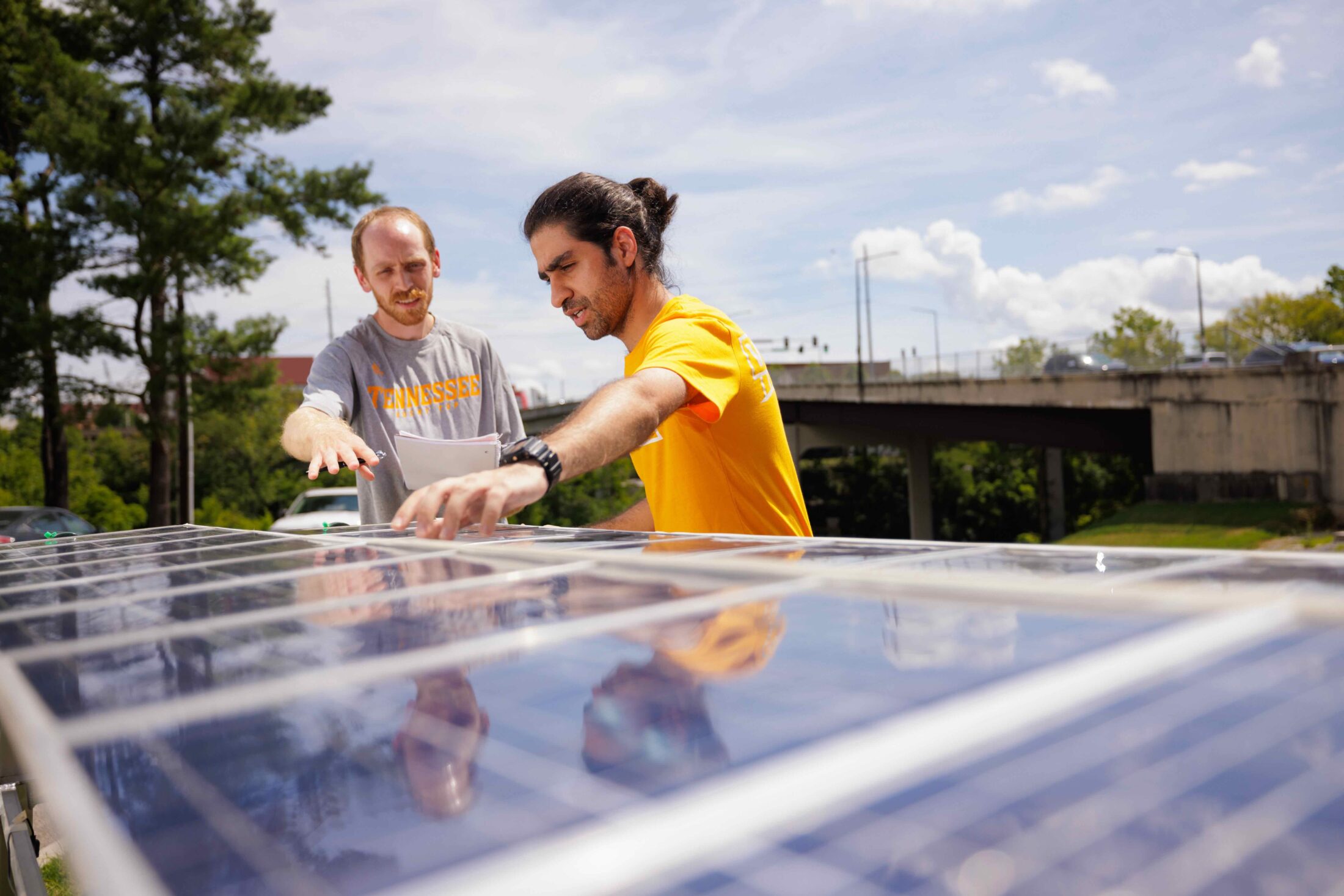 Jonathan Yoder, 3rd year biosystems engineering grad student, and Ahmad Amirirojdanr, 3rd year biosystems engineering grad student, work with an agrovoltaic system outside the Smart Agriculture Lab in the Biosystems Engineering and Soil Science building