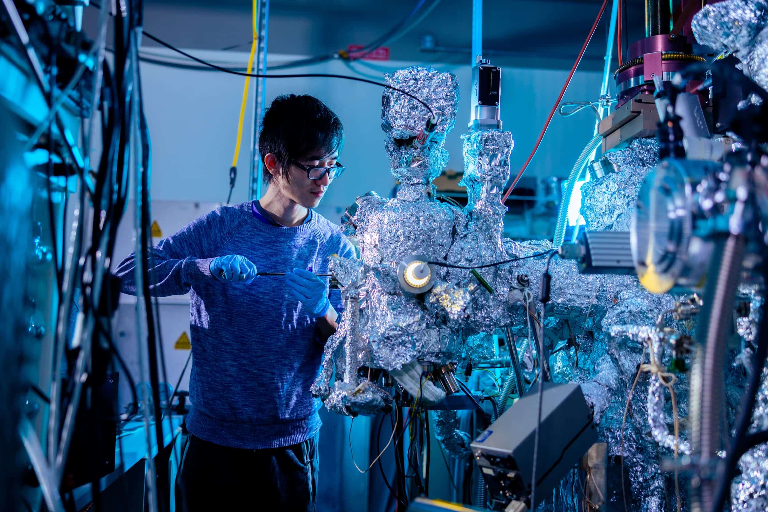 A male researcher uses a tool on the advanced photoelectron spectrometer.