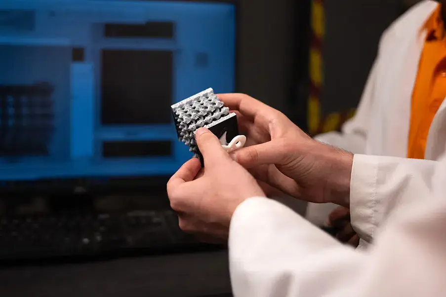 A researcher holds a sample in the Penumadu x-ray lab at the University of Tennessee, Knoxville