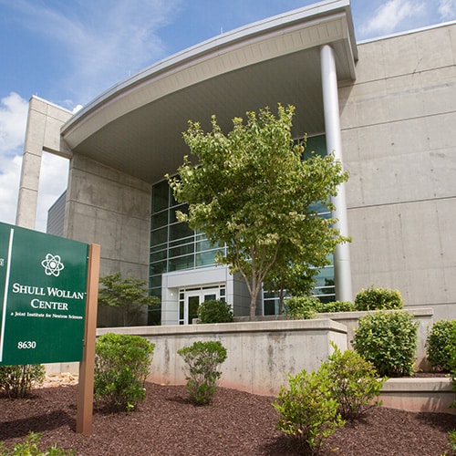 Entrance to the Shull Wollan Center with a green sign indicating the building name.