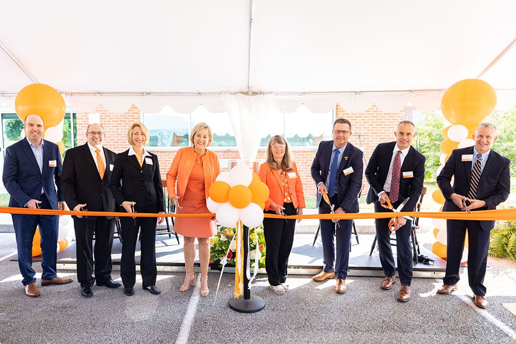 Several people from UT and Eastman cut an orange ribbon at a ceremony for the Eastman Innovation Center.