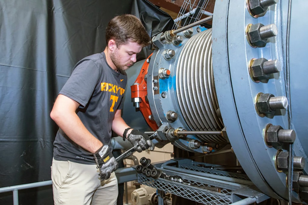 A student uses a wrench on the wind tunnel at the UT Space Institute.