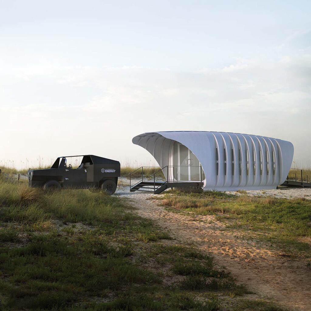 On a grassy piece of flat land, a green jeep sits in front of AMIE, a moveable 3D-printed structure with a white exterior.
