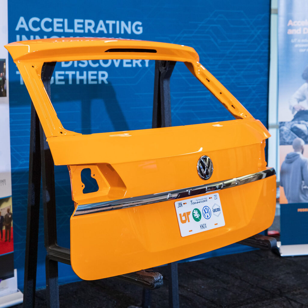 An orange liftgate stands in front of a blue banner.