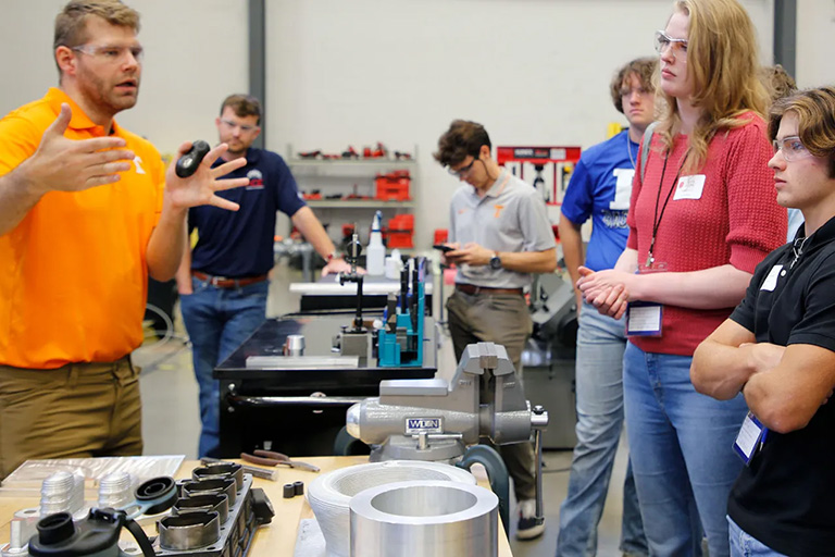 Rob Patterson explains his advanced manufacturing equipment to a group of high school students.