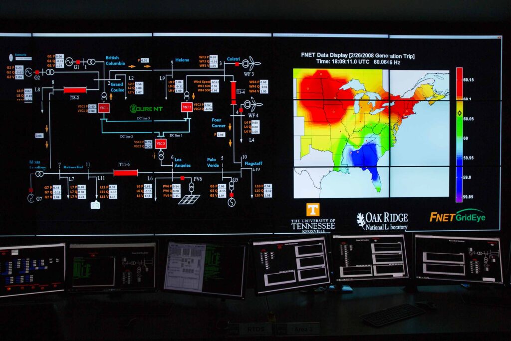 A large wall of screens showing data, including a map, in a CURENT lab.
