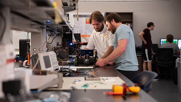 Two students work on a autonomous vehicle in the Neuromorphic Computing Lab.