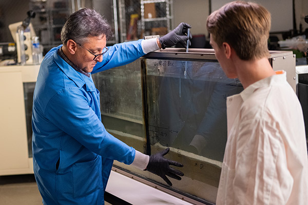Research Associate and Technical Manager Adrian Gonzalez prepares to inject dye in sand in a seepage and drainage bench tester as students record data in the Water Resources/Hydraulics Lab in the John D. Tickle Engineering Building at the University of Tennessee.