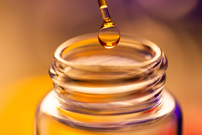 Detail photo of a solution droplet on the end of a glass dropper before going into a glass vial in the Polymer Characterization Laboratory at the University of Tennessee.