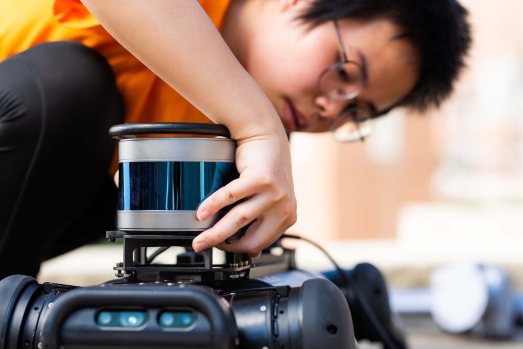 Mengjun Wang installs LiDAR on the top of a robot dog.