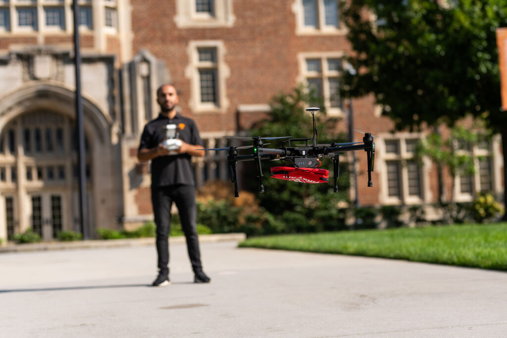 Sabrullah Deniz works with a drone carrying a first-aid kit on the lawn outside Ayres Hall.
