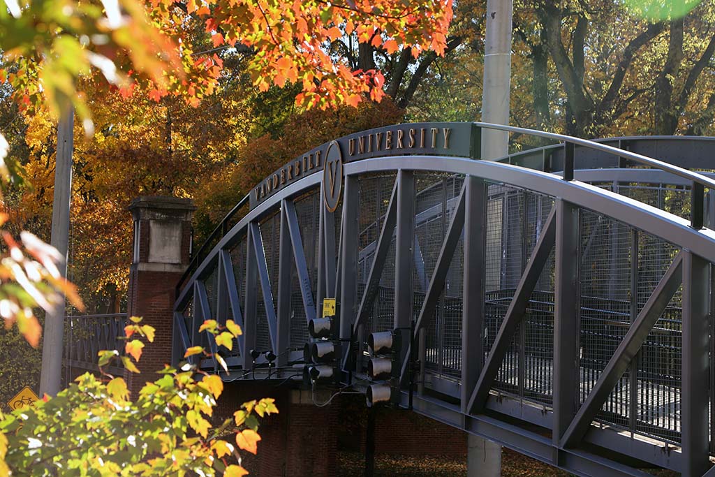 Black metal bridge with letters spelling Vanderbilt University surrounded by fall foliage; provided by Li Yuanhe on Unsplash. 