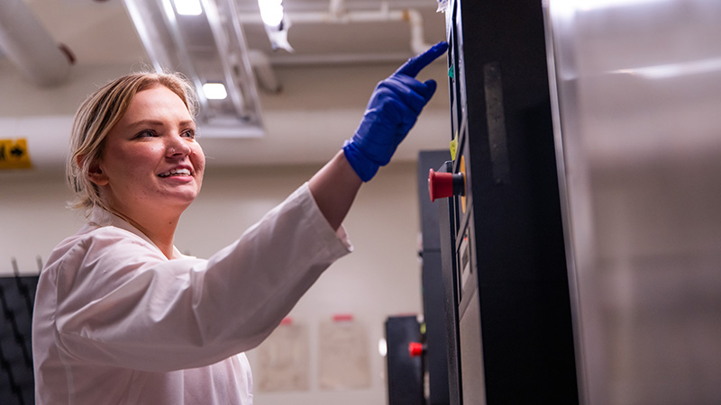 PhD student Carrie Sanford removes items from an autoclave in a Senter Hall lab.