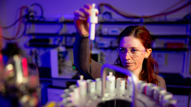 Placing samples in a nuclear magnetic resonance spectroscopy in the Polymer Characterization Laboratory.