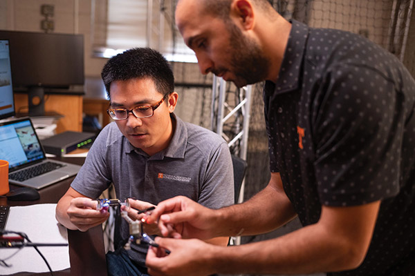 Assistant Professor Zhenbo Wang examines a drone.