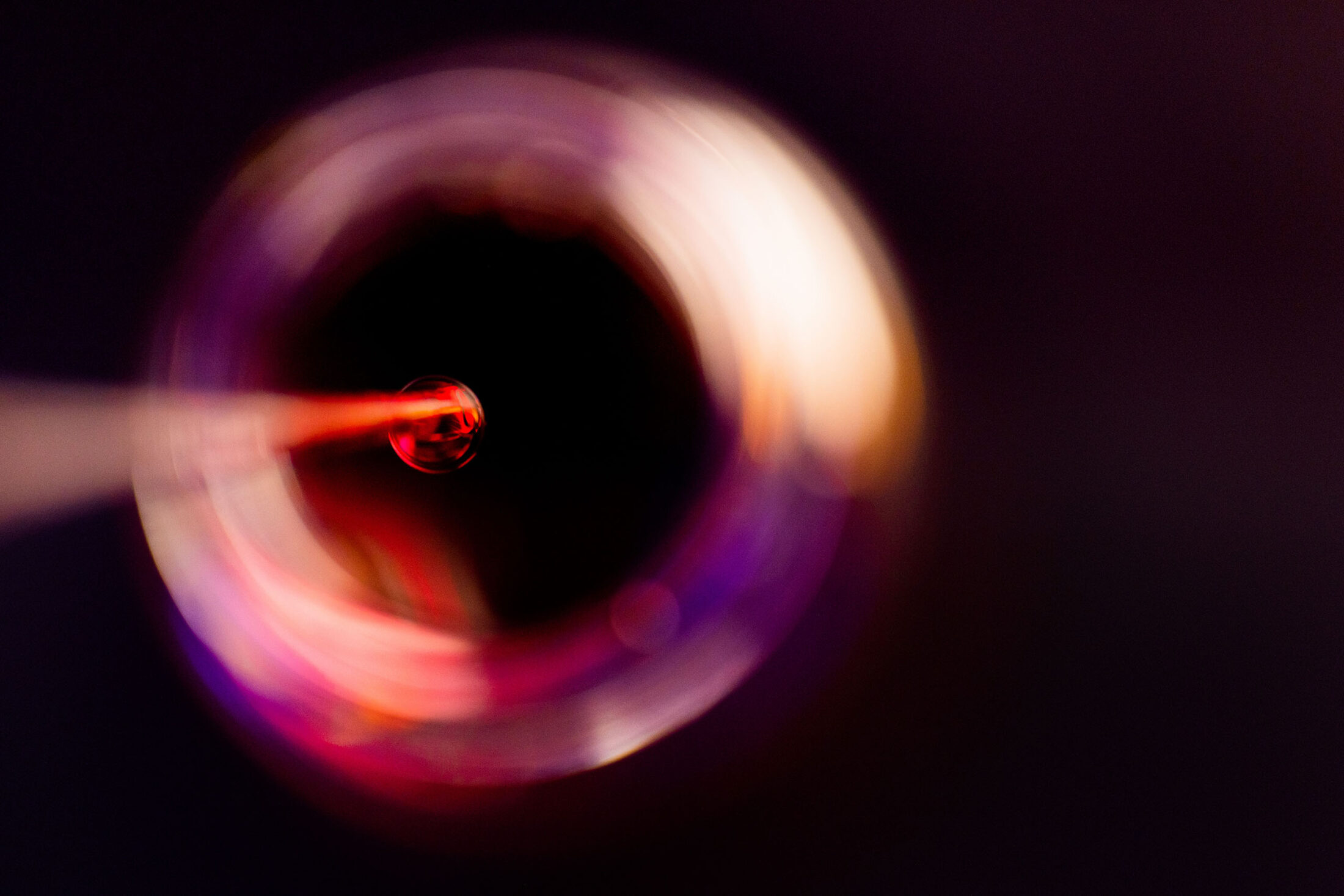 Overhead view of a pipette dropping a sample into a small jar.