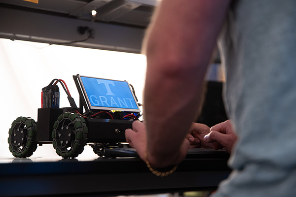 A man works on an autonomous vehicle in a neuromorphic computing lab .