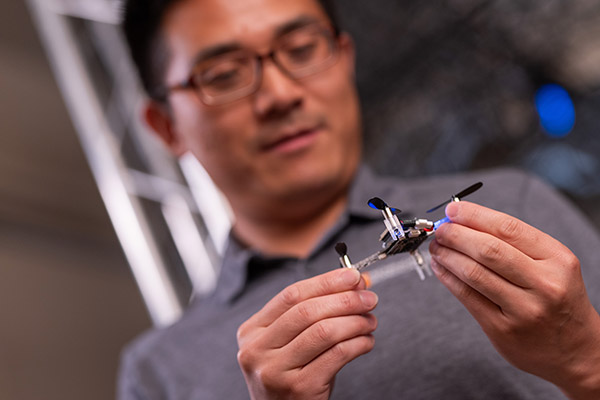 A man holds a nano drone in the Autonomous Systems Laboratory.
