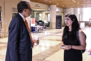 Victor McCrary, Vice Chancellor for Research and Engagement, talks with a student after her presentation at the Undergraduate Research Symposium at the John C. Hodges Library.