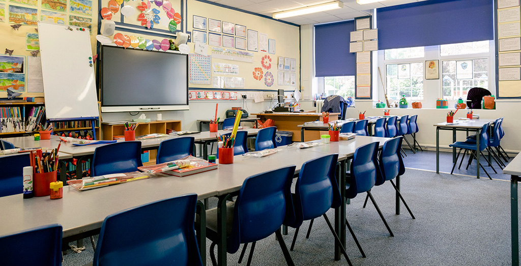 A wide angle view of an organized classroom in an elementary school.