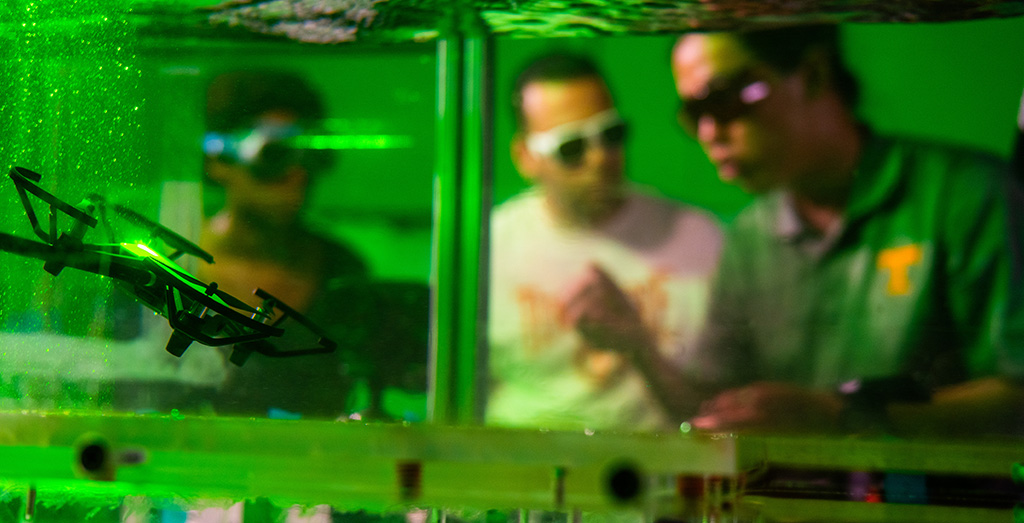 Haochen Li explains research behind a drone operating in a flume filled with water.