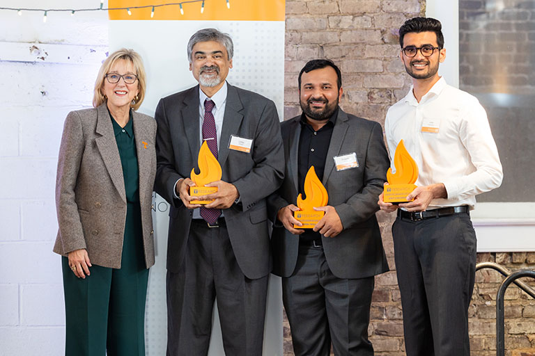 Chancellor Donde Plowman presents an award to Uday Vaidya, Pritesh Yeole and Vinit Chaudhary during the Chancellor's Innovation Fund Awards Ceremony at the Emporium.