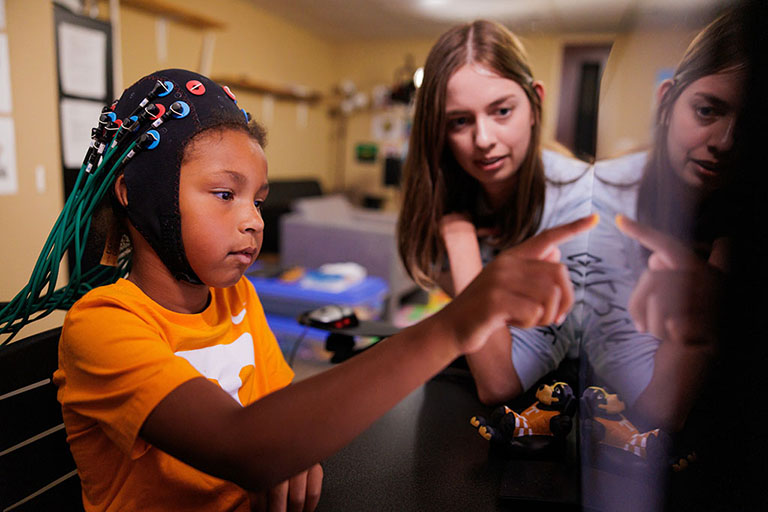 Alexis McCraw uses computer games to stimulate a minor’s brain waves in order to gain a better understanding of different aspects of child development in the Attention, Brain, and Cognition Lab at the University of Tennessee.