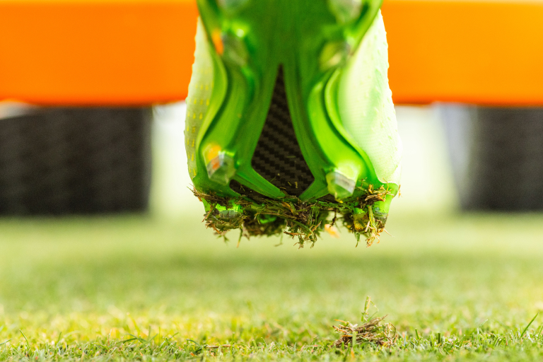 A cleat attached to the fLEX Device is used to test a turfgrass surface.