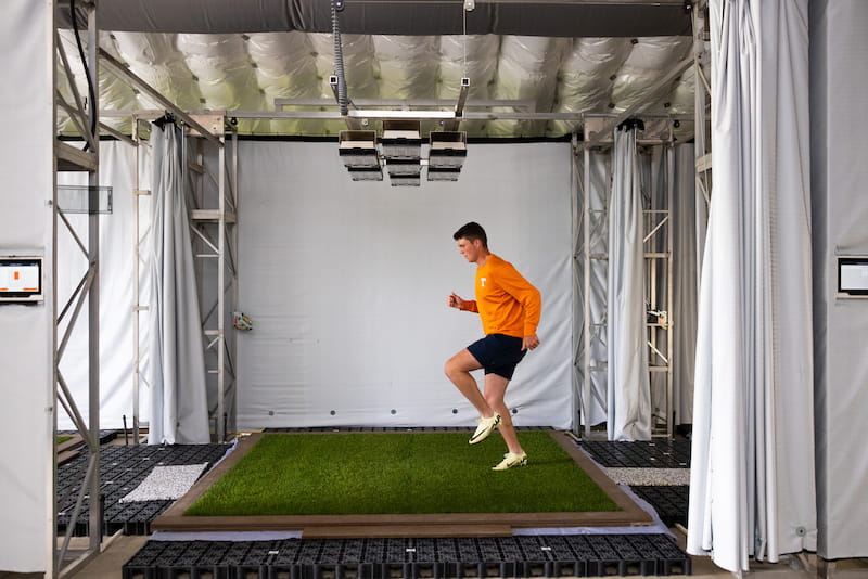 Athlete running in indoor turfgrass athletic research facility