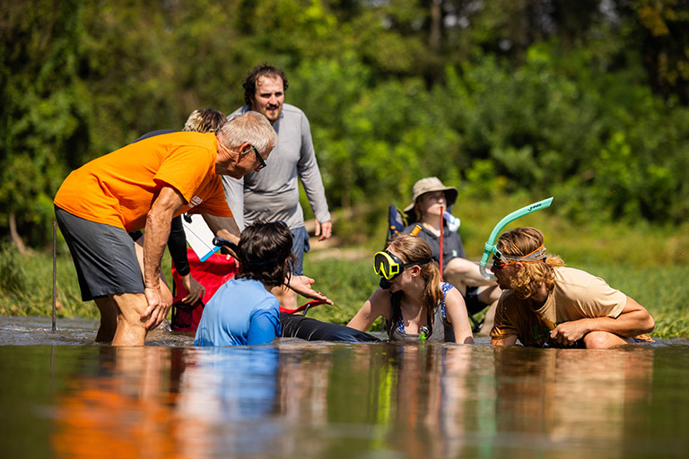 Gerry Dinkins, Curator of Natural History and Malacology at McClung Museum of Natural History and Culture at the University of Tennessee, reviews and discusses the collections of undergrad students in a shoal along the Nolichucky River.