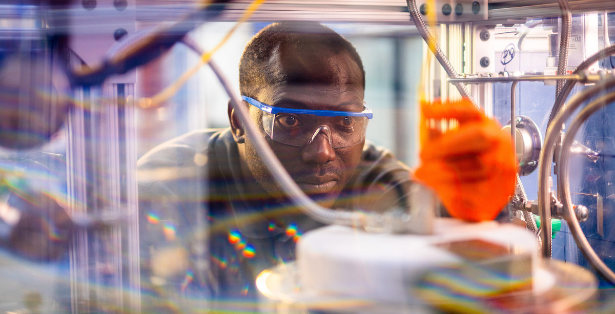 A man looks into a CO2-to-jet fuel reactor in a bioenergy and biofuels lab.
